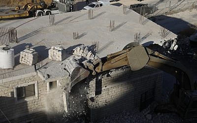 Les forces de sécurité israéliennes démolissant les bâtiments palestiniens encore en construction qui ont fait l'objet d'avis de démolition dans la zone de Wadi al-Hummus adjacente au village palestinien de Sur Baher à Jérusalem-Est, 22 juillet 2019. (Ahmad GHARABLI / AFP)