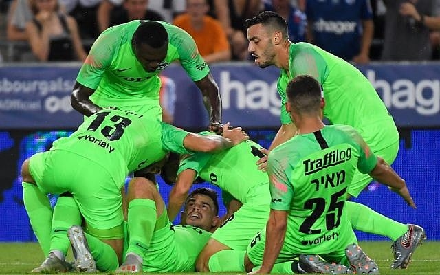 Le milieu de terrain ukrainien du Maccabi Haifa, Maxim Plakushchenko (au centre), célèbre son but avec ses coéquipiers, lors du match de football aller du 2e tour préliminaire de l'UEFA Europa League entre Strasbourg et le Maccabi Haifa au stade de la Meinau, à Strasbourg, le 25 juillet 2019. (PATRICK HERTZOG / AFP)