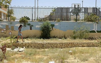 Une jeune femme longe une fresque murale dans un jardin de Yerucham, le 28 juin 2014. (Zoe Vayer/Flash90)