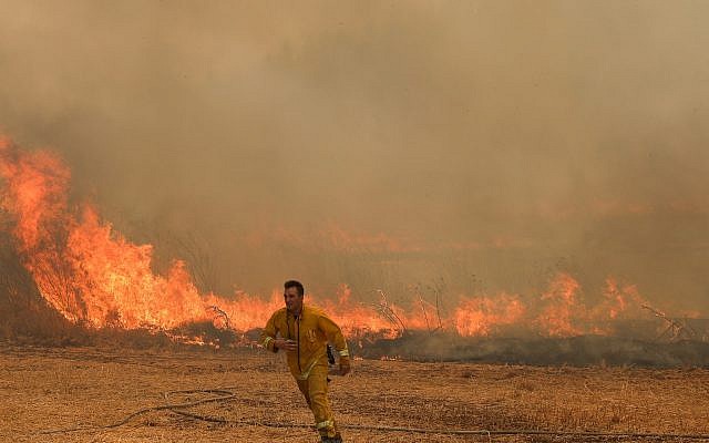 Des pompiers tentent d'éteindre un incendie de broussailles près de Moshav Aderet, le 17 juillet 2019. (Noam Revkin Fenton/Flash90) Des pompiers tentent d'éteindre un incendie de broussailles près de Moshav Aderet, le 17 juillet 2019. (Noam Revkin Fenton/Flash90)