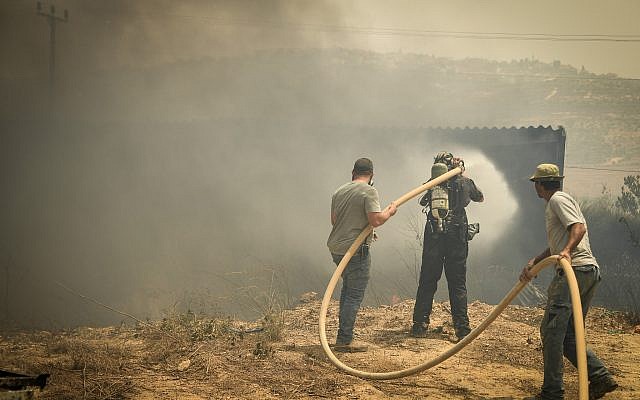 Des volontaires tentent d'éteindre un incendie dans l'implantation de Shavei Shomron en Cisjordanie, le 17 juillet 2019. (Sraya Diamant/Flash90) Des volontaires tentent d'éteindre un incendie dans l'implantation de Shavei Shomron en Cisjordanie, le 17 juillet 2019. (Sraya Diamant/Flash90)