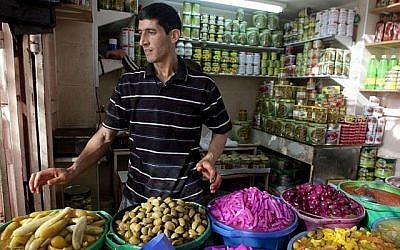 Un vendeur palestinien de la ville de Hébron, en Cisjordanie, se prépare au Ramadan au mois de juin 2014 (Crédit : AP/ Majdi Mohammed)