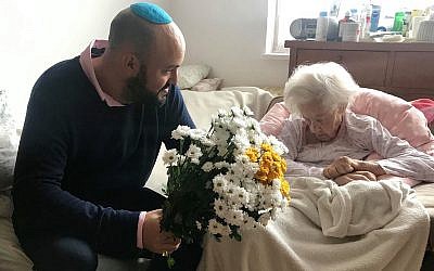 Krystyna Danko reçoit des fleurs de Jonny Daniels dans son appartement de Varsovie, en Pologne, pour son 102e anniversaire, le 9 juillet 2019 (Crédit : From the Depths via JTA)