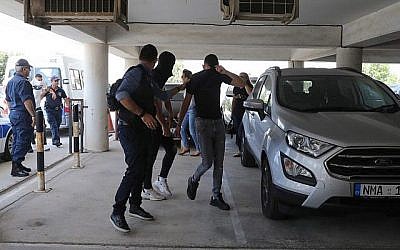 Douze touristes israéliens, suspectés d'avoir violé une jeune femme britannique de 19 ans à Ayia Napa, arrivent au tribunal à l'est de la station balnéaire chypriote de Paralimni le 18 juillet 2019, pour une audience tenue à huis clos. (AFP)