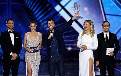 Duncan Laurence des Pays-Bas, au centre, exulte après avoir remporté la grande finale du concours de l'Eurovision 2019 avec la chanson "Arcade" à Tel Aviv, le 18 mai 2019. Il est entouré des quatre présentateurs (en partant de la gauche) : Aussi Azar, Lucy Ayoub, Bar Refaeli et Erez Tal. (AP Photo/Sebastian Scheiner)