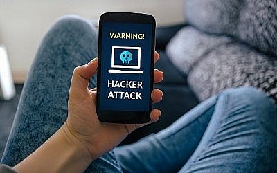 Un téléphone portable avec un avertissement de piratage informatique.
(iStock de Getty Images/ CarmenMurillo)