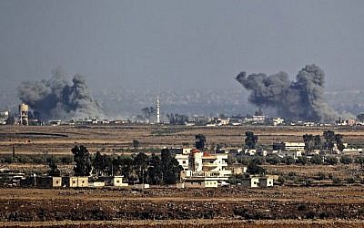 A titre d'illustration : Une photo prise le 26 juillet 2018, près du kibboutz Ein Zivan, sur le plateau du Golan israélien, montre de la fumée s'élevant de l'autre côté de la frontière syrienne à la suite des attaques aériennes menées dans la province de Quneitra, au sud du pays par le gouvernement syrien, lors d'une offensive. (AFP Photo/Jack Guez) A titre d'illustration : Une photo prise le 26 juillet 2018, près du kibboutz Ein Zivan, sur le plateau du Golan israélien, montre de la fumée s'élevant de l'autre côté de la frontière syrienne à la suite des attaques aériennes menées dans la province de Quneitra, au sud du pays par le gouvernement syrien, lors d'une offensive. (AFP Photo/Jack Guez)