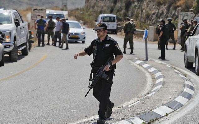 Les forces de sécurité sur le site de l'explosion d'une bombe aux abords de l'implantation israélienne de Dolev, en Cisjordanie, le 23 août 2019 (Crédit : Ahmad GHARABLI / AFP) Les forces de sécurité sur le site de l'explosion d'une bombe aux abords de l'implantation israélienne de Dolev, en Cisjordanie, le 23 août 2019 (Crédit : Ahmad GHARABLI / AFP)