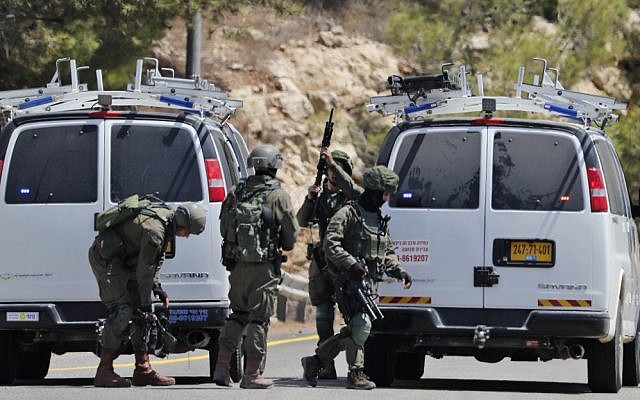 Les forces de sécurité sur le site de l'explosion d'une bombe aux abords de l'implantation israélienne de Dolev, en Cisjordanie, le 23 août 2019 (Crédit : Ahmad GHARABLI / AFP) Les forces de sécurité sur le site de l'explosion d'une bombe aux abords de l'implantation israélienne de Dolev, en Cisjordanie, le 23 août 2019 (Crédit : Ahmad GHARABLI / AFP)