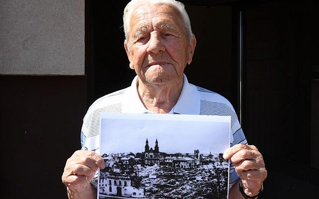 Tadeusz Sierandt, un témoin du bombardement de Wielun tient une photographie de la ville détruite le 20 août 2019. (Crédit : Janek SKARZYNSKI / AFP) Tadeusz Sierandt, un témoin du bombardement de Wielun tient une photographie de la ville détruite le 20 août 2019. (Crédit : Janek SKARZYNSKI / AFP)