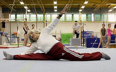 Agnes Keleti fait le grand écart devant de jeunes gymnastes hongroises, à Budapest le 16 janvier 2016. (Crédit : Peter Kohalmi/AFP/Getty Images/via JTA)