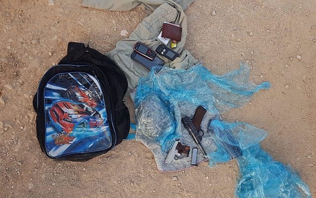 Des pistolets et des munitions trouvés dans un cartable d'écolier transporté par deux Palestiniens depuis le nord de la Cisjordanie, le 5 août 2019. (Crédit : armée israélienne)