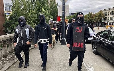 Des contre-manifestants anti-fascistes traversent le pont Burnside à la recherche du groupe d'extrême droite Proud Boys, à Portland, le 17 août 2019. (Crédit : AP Photo/Gillian Flaccus)