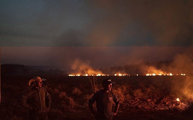 Neri dos Santos Silva, au centre, observe un feu creuser des tranchées à Nova Santa Helena ,au Brésil, le 23 août 2019. (Crédit : AP/Leo Correa) Neri dos Santos Silva, au centre, observe un feu creuser des tranchées à Nova Santa Helena ,au Brésil, le 23 août 2019. (Crédit : AP/Leo Correa)