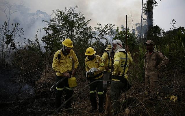 Des pompiers luttent contre les flammes en Amazonie, dans la ville de Port Velho, au Brésil, le 26 août 2019. (Crédit : /Eraldo Peres)