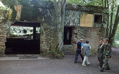 Des touristes visitent les ruines du quartier-général d'Adolf Hitler, la Tanière du loup, à  Gierloz, dans le nord-est de la Pologne, où il avait été victime d'une tentative d'assassinat, le 20 août 1944. Photo prise le 17 juillet 2004 (Crédit : AP Photo/Czarek Sokolowski, File)