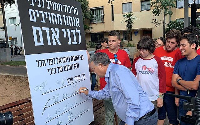 Le dirigeant du Parti travailliste Amir Peretz signe l'engagement du parti en faveur des valeurs humaines, Tel Aviv, le 4 août 2019. (Autorisation)