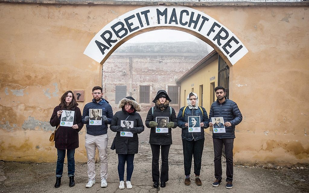 Elan Kawesch (deuxième à partir de la gauche) et les participants avec des photos des victimes à l'intérieur de la "petite forteresse" de Terezin, en République tchèque, février 2019. (Matt Lebovic/The Times of Israel)