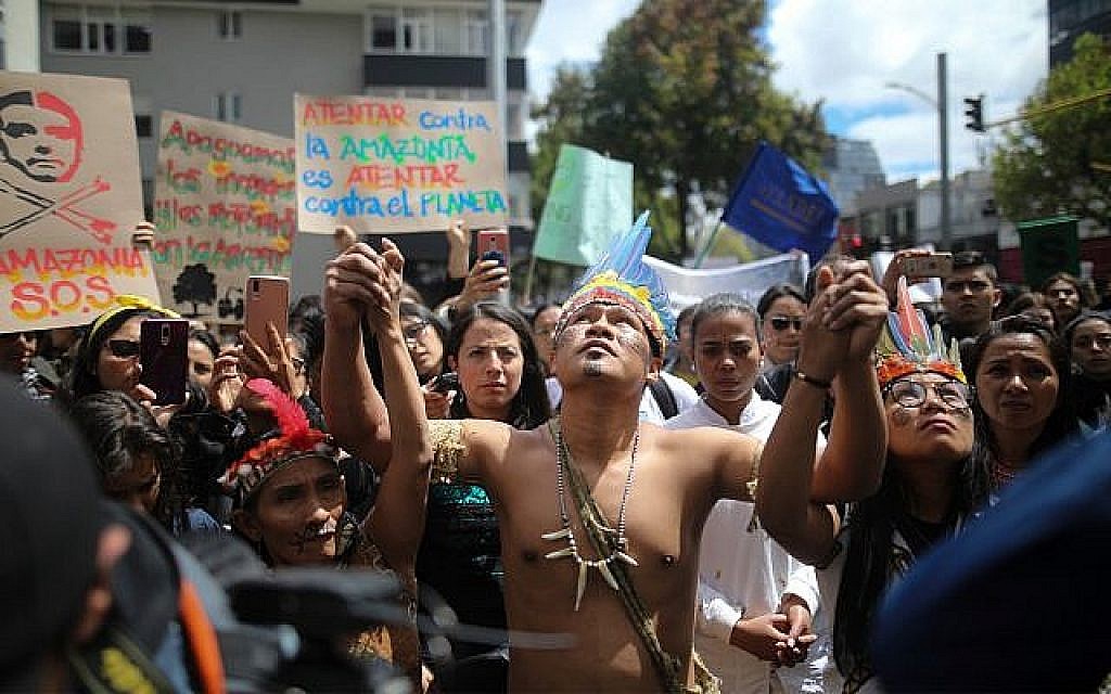 Des manifestants indigènes lors d'un rassemblement aux abords de l'ambassade du Brésil appelant le président Jair Bolsonaro à agir pour la protection de la forêt amazonienne à Bogota, en Colombie, le 23 août 2019 (Crédit : AP Photo/Ivan Valencia)