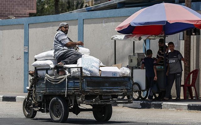 Un Palestinien se trouve sur un pickup transportant un sac d'aide alimentaire fourni par l'UNRWA au sud de Gaza ville à Rafah, le 25 juin 2019. (Said Khatib/AFP) Un Palestinien se trouve sur un pickup transportant un sac d'aide alimentaire fourni par l'UNRWA au sud de Gaza ville à Rafah, le 25 juin 2019. (Said Khatib/AFP)
