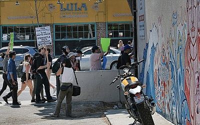 Des manifestants portent des pancartes pour dénoncer le racisme dans la rue principale de la zone de Venice Beach à Los Angeles, le dimanche 19 août 2017. (AP Photo/Richard Vogel)
