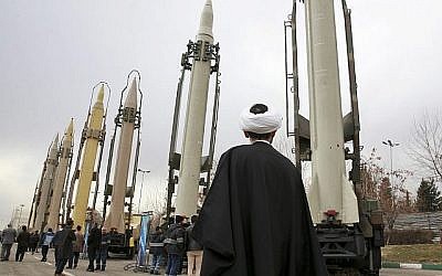 Un religieux iranien observe les missiles sol-sol développés en Iran alors qu'ils sont exposés par les Gardes de la Révolution dans une présentation militaire marquant le 40ème anniversaire de la Révolution islamique, à la grande mosquée de l'Imam Khomeini à Téhéran, en Iran le 3 février 2019. (Crédit : Vahid Salemi/AP)