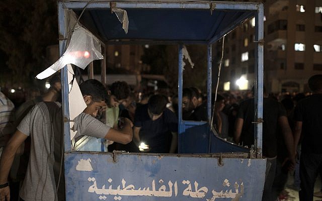 Des Palestiniens observent un poste de contrôle de la police après qu'une exposition a ciblé un barrage de la police à Gaza Ville, le mardi 27 août 2019. (AP Photo/Khalil Hamra) Des Palestiniens observent un poste de contrôle de la police après qu'une exposition a ciblé un barrage de la police à Gaza Ville, le mardi 27 août 2019. (AP Photo/Khalil Hamra)