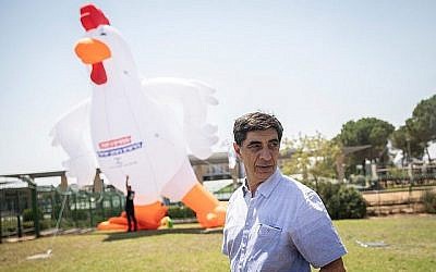 Simcha Goldin, le père du soldat israélien mort au combat Hadar Goldin, se trouve à côté d'un coq gonflable de 10 mètres de haut lors d'une manifestation devant la Knesset le 14 août 2019. (Hadas Parush/Flash90)