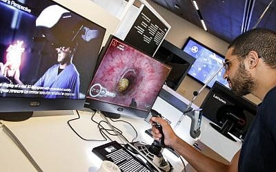 Un visiteur utilise un joystick pour examiner un coeur virtuel, lors d'une expositions de RealView, au Centre Peres pour la paix et l'innovation de Tel-Aviv, le 3 septembre 2019. (Crédit : JACK GUEZ / AFP)