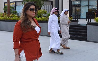 Mashael al-Jaloud, 33 ans et responsable de ressources humaines, marche devant des Saoudiens vêtus de la tenue traditionnelle, elle-même sans abaya, à Riyad, le 3 septembre 2019. FAYEZ NURELDINE / AFP)