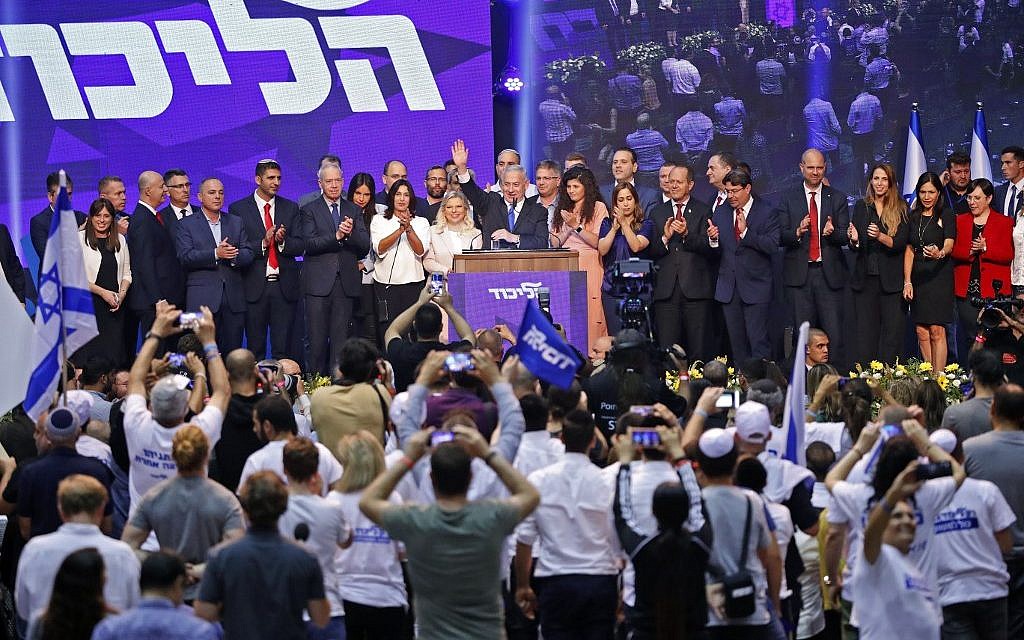 Le Premier ministre israélien Benjamin Netanyahu (C) fait un signe de la main alors qu'il s'adresse à des partisans au siège de la campagne électorale de son parti, le Likud, le 18 septembre 2019. (Crédit : Jack GUEZ / AFP)