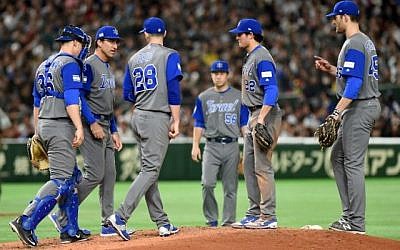 Les joueurs israéliens et un coach autour du joueur Josh Zeid (#28) pendant le match entre Israël et le Japon au Dôme de Tokyo à Tokyo, le 15 mars 2017 (Crédit : AFP PHOTO / TORU YAMANAKA)