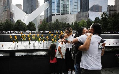 Des enfants de victimes, tuées le 11 septembre 2001, s'étreignent au National September 11 Memorial pendant une cérémonie commémorative du matin pour les victimes des attaques terroristes 18 ans après, le 11 septembre 2019 à New York City. Dans tout le pays, des cérémonies ont été organisés pour commémorer les 2 977 personnes tuées à New York, au Pentagone et dans un champ en Pennsylvanie. New York, le 11 septembre 2019. (Spencer Plate/Getty Images/AFP)