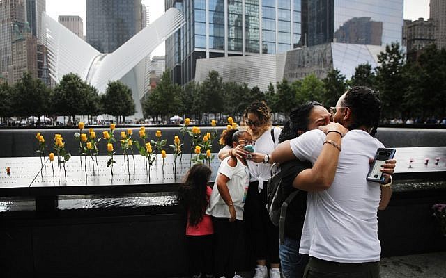 Des enfants de victimes, tuées le 11 septembre 2001, s'étreignent au National September 11 Memorial pendant une cérémonie commémorative du matin pour les victimes des attaques terroristes 18 ans après, le 11 septembre 2019 à New York City. Dans tout le pays, des cérémonies ont été organisés pour commémorer les 2 977 personnes tuées à New York, au Pentagone et dans un champ en Pennsylvanie. New York, le 11 septembre 2019. (Spencer Plate/Getty Images/AFP)