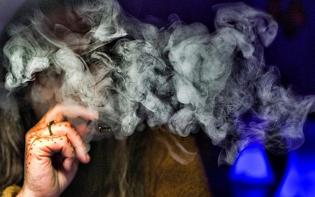 Une femme fume du cannabis avec une cigarette électronique, à Los Angeles, le 22 novembre 2018, (Crédit : AP/Richard Vogel)