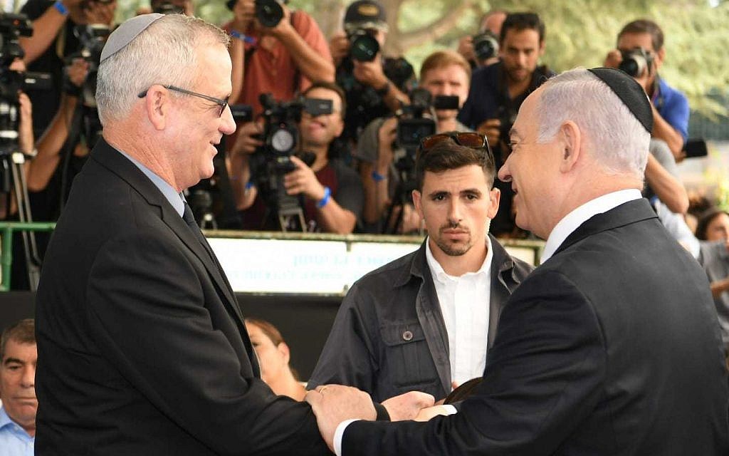 Le Premier ministre Benjamin Netanyahu (à droite) et le chef du parti Kakhol lavan Benny Gantz se serrant la main lors d'une cérémonie en mémoire de l'ancien président Shimon Peres à Jérusalem, le 19 septembre 2019. (GPO)