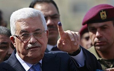 Le président de l'Autorité palestinienne Mahmoud Abbas brandit son doigt plein d'encore après avoir mis son bulletin dans l'urne au cours des élections locales dans un bureau de vote de Ramallah, en Cisjordanie, le 20 octobre 2012 (Crédit :  AP/Majdi Mohammed)