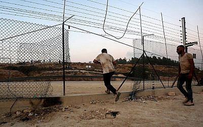Des Palestiniens traversent illégalement une barrière de sécurité pour entrer en Israël autour de la ville d'Hébron en Cisjordanie, le 6 août 2019. (Wisam Hashlamoun/Flash90)