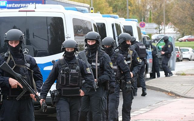 Des policiers traversent une rue proche du lieu d'une fusillade à Halle, dans l'est de l'Allemagne, le 9 octobre 2019. (Crédit : Sebastian Willnow / dpa / AFP) / Allemagne OUT Des policiers traversent une rue proche du lieu d'une fusillade à Halle, dans l'est de l'Allemagne, le 9 octobre 2019. (Crédit : Sebastian Willnow / dpa / AFP) / Allemagne OUT