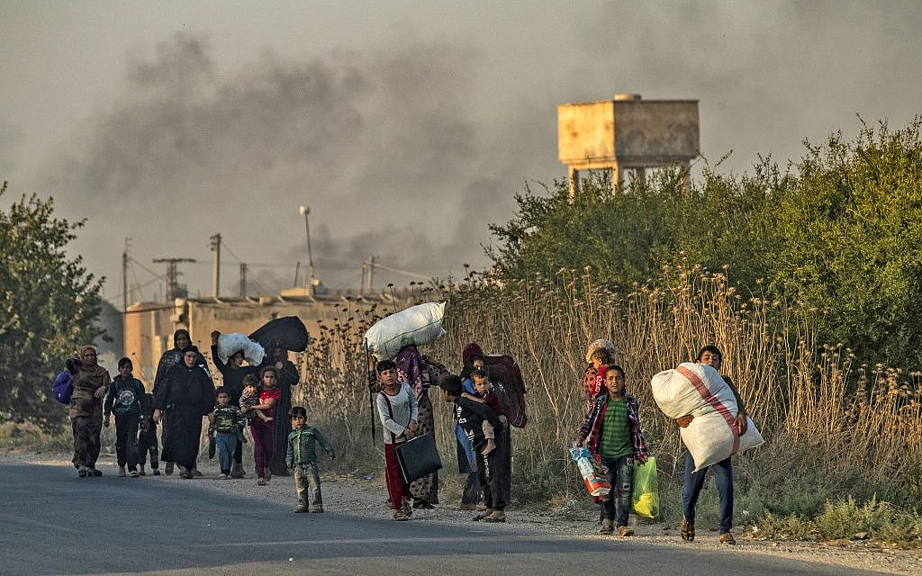 Des civils syriens arabes et kurdes fuient avec leurs biens au milieu des bombardements turcs sur la ville de Ras al-Ain, au nord-est de la Syrie, le 9 octobre 2019. (Delil SOULEIMAN / AFP)