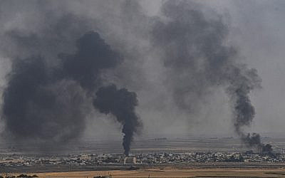 De la fumée monte de la ville syrienne de Ras al-Ain, sur une photo prise du côté turc de la frontière à Ceylanpinar le 11 octobre 2019, le troisième jour de l'opération militaire turque contre les forces kurdes. (Crédit : Ozan KOSE / AFP)