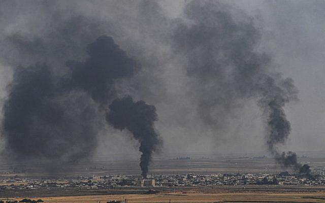 De la fumée monte de la ville syrienne de Ras al-Ain, sur une photo prise du côté turc de la frontière à Ceylanpinar le 11 octobre 2019, le troisième jour de l'opération militaire turque contre les forces kurdes. (Crédit : Ozan KOSE / AFP) De la fumée monte de la ville syrienne de Ras al-Ain, sur une photo prise du côté turc de la frontière à Ceylanpinar le 11 octobre 2019, le troisième jour de l'opération militaire turque contre les forces kurdes. (Crédit : Ozan KOSE / AFP)
