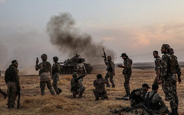 Des soldats turcs et des combattants syriens soutenus par la Turquie se rassemblent à la périphérie nord de la ville syrienne de Manbij, près de la frontière turque, le 14 octobre 2019, alors que la Turquie et ses alliés poursuivent leur attaque contre les villes frontalières kurdes du nord-est du pays. (Zein Al RIFAI / AFP)