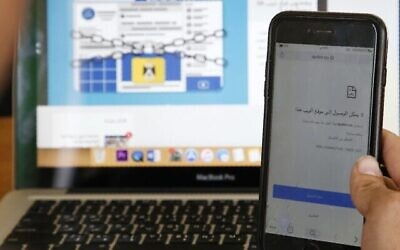 Une photo prise le 23 octobre 2019 montre un Palestinien tenant un téléphone portable et affichant le message "ce site n'est pas accessible" dans un bureau de la ville d'Hébron en Cisjordanie, suite à la décision d'un tribunal de Ramallah de bloquer l'accès à des dizaines de sites. (HAZEM BADER / AFP)