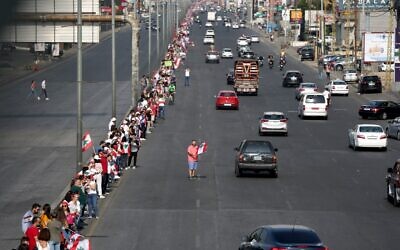 Des manifestants forment une chaîne humaine le long de la côte du nord au sud pour symboliser l'unité, pendant des manifestations anti-gouvernement, le 27 octobre 2019. La chaîne humaine rejoint Tripoli à Tyre et s'étend sur 170 kilomètres, en traversant Beyrouth. (Crédit : Patrick BAZ / AFP) Des manifestants forment une chaîne humaine le long de la côte du nord au sud pour symboliser l'unité, pendant des manifestations anti-gouvernement, le 27 octobre 2019. La chaîne humaine rejoint Tripoli à Tyre et s'étend sur 170 kilomètres, en traversant Beyrouth. (Crédit : Patrick BAZ / AFP)