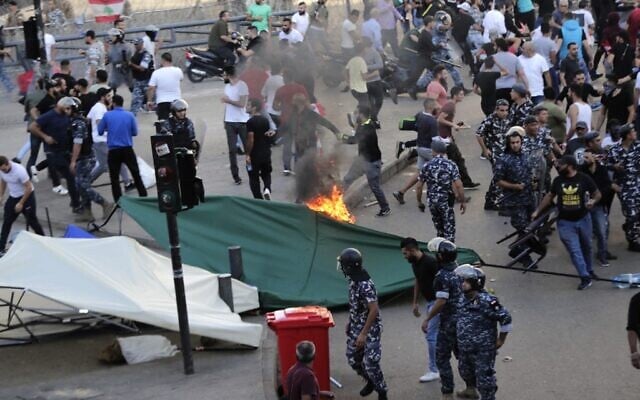 La police libanaise tente de séparer manifestants et contre-manifestants durant un mouvement de protestation à Beyrouth, le 29 octobre 2019. (Crédit : ANWAR AMRO / AFP) La police libanaise tente de séparer manifestants et contre-manifestants durant un mouvement de protestation à Beyrouth, le 29 octobre 2019. (Crédit : ANWAR AMRO / AFP)