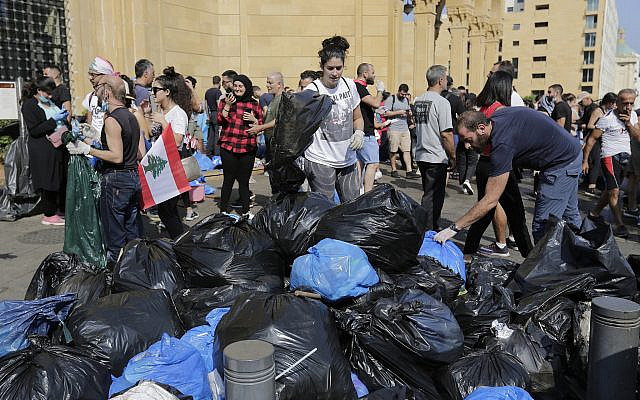 Des bénévoles aident à nettoyer les rues après les manifestations violentes contre le gouvernement libanais à Beyrouth, au Liban, le 21 octobre 2019 (Crédit : AP Photo/Hassan Ammar) Des bénévoles aident à nettoyer les rues après les manifestations violentes contre le gouvernement libanais à Beyrouth, au Liban, le 21 octobre 2019 (Crédit : AP Photo/Hassan Ammar)