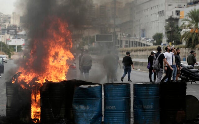 Des manifestants anti-gouvernements incendient des pneus pour bloquer une autoroute qui relie Beyriuth au nord du Liban à Zouk Mosbeh, le 28 octobre 2019. (Crédit : AP Photo/Hassan Ammar) Des manifestants anti-gouvernements incendient des pneus pour bloquer une autoroute qui relie Beyriuth au nord du Liban à Zouk Mosbeh, le 28 octobre 2019. (Crédit : AP Photo/Hassan Ammar)