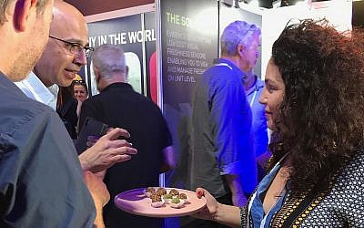 Une femme propose des produits alimentaires innovants aux participants de l'événement FoodTechIL à Tel Aviv, le 23 septembre 2019. (Shoshanna Solomon/Times of Israel)
