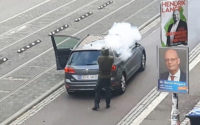 Un homme armé tire dans une rue de Halle, en Allemagne, après une fusillade devant une synagogue dans la même ville, faisant deux morts. (Crédit : capture d'écran / Andreas Splett / ATV-Studio Halle / AFP) Un homme armé tire dans une rue de Halle, en Allemagne, après une fusillade devant une synagogue dans la même ville, faisant deux morts. (Crédit : capture d'écran / Andreas Splett / ATV-Studio Halle / AFP)
